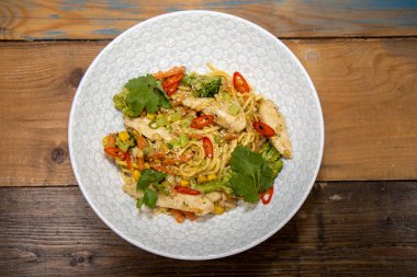 Mutfakta beyaz bir kasede lezzetli bir fırında zencefil ve fıstık tavuklu şehriye tabağı.