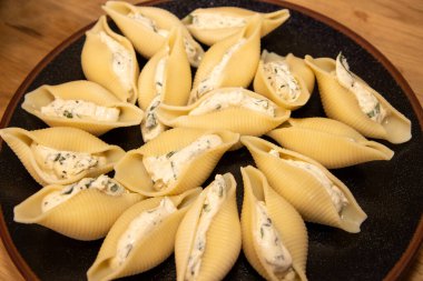 Bir tabak lezzetli ıspanak ve Ricotta makarna kabuğu ahşap mutfak kapağında, fırına konmaya hazır.