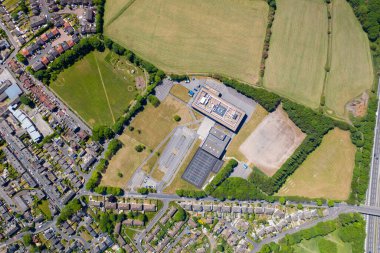 Whitcliffe Dağı İlköğretim Okulu 'nun tepeden aşağı insansız hava aracı fotoğrafı, açık güneşli bir yaz gününde İngiliz okul binasının ve konut evlerinin havadan çekilmiş bir fotoğrafını gösteriyor.