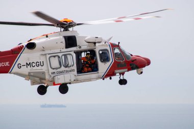 Doğu Sussex, Beachy Head, İngiltere 10 Temmuz 2019: HM Sahil Güvenlik Kurtarma Helikopteri, okyanus üzerindeki bulutlu bir günde, Beachy Head uçurumlarında meydana gelen bir olaya katıldı..
