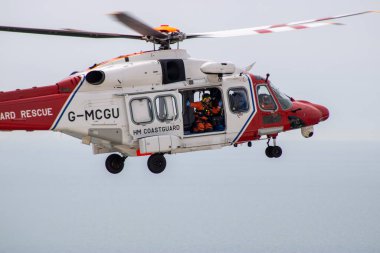 Doğu Sussex, Beachy Head, İngiltere 10 Temmuz 2019: HM Sahil Güvenlik Kurtarma Helikopteri, okyanus üzerindeki bulutlu bir günde, Beachy Head uçurumlarında meydana gelen bir olaya katıldı..