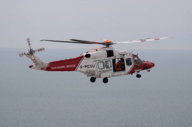 Doğu Sussex, Beachy Head, İngiltere 10 Temmuz 2019: HM Sahil Güvenlik Kurtarma Helikopteri, okyanus üzerindeki bulutlu bir günde, Beachy Head uçurumlarında meydana gelen bir olaya katıldı..