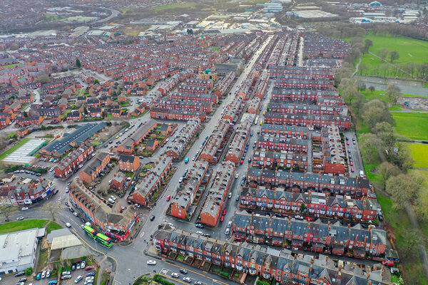 Аэрофотоснимок деревни Бистон в Лидсе Западный Йоркшир, показывающий типичный британский парк вдоль боковых рядов террас домов, дорог и улиц, сделанный зимой в сырой холодный день.