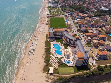 Bulgaristan 'ın Obzor kenti olarak bilinen güzel küçük kasaba ve sahil beldesinin hava fotoğrafı Karadeniz kıyısındaki altın güneşli sahilde dinlenen ve eğlenen insanları gösteriyor.