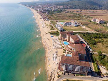 Bulgaristan 'ın Obzor kenti olarak bilinen güzel küçük kasaba ve sahil beldesinin hava fotoğrafı Karadeniz kıyısındaki altın güneşli sahilde dinlenen ve eğlenen insanları gösteriyor.