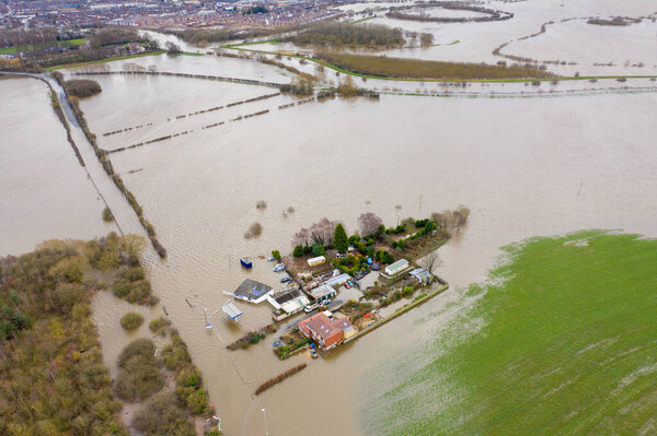 Aerial drone photo of the town of Allerton Bywater near Castleford in Leeds West Yorkshire showing the flooded fields and farm house from the River Aire during a large flood after a storm.
