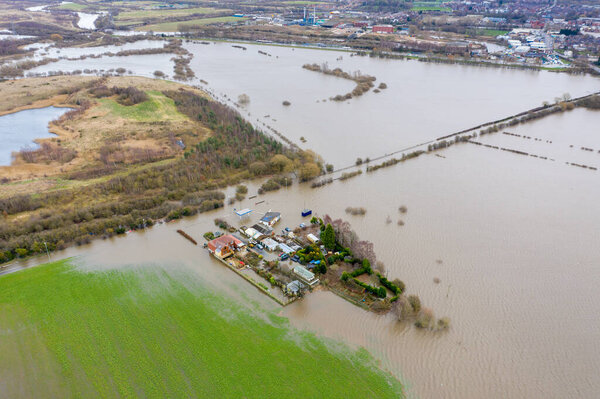 Aerial drone photo of the town of Allerton Bywater near Castleford in Leeds West Yorkshire showing the flooded fields and farm house from the River Aire during a large flood after a storm.