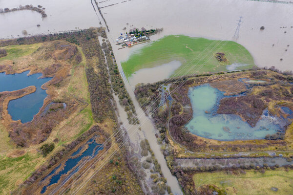 Aerial drone photo of the town of Allerton Bywater near Castleford in Leeds West Yorkshire showing the flooded fields and farm house from the River Aire during a large flood after a storm.
