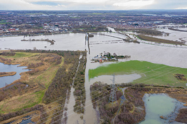 Aerial drone photo of the town of Allerton Bywater near Castleford in Leeds West Yorkshire showing the flooded fields and farm house from the River Aire during a large flood after a storm.