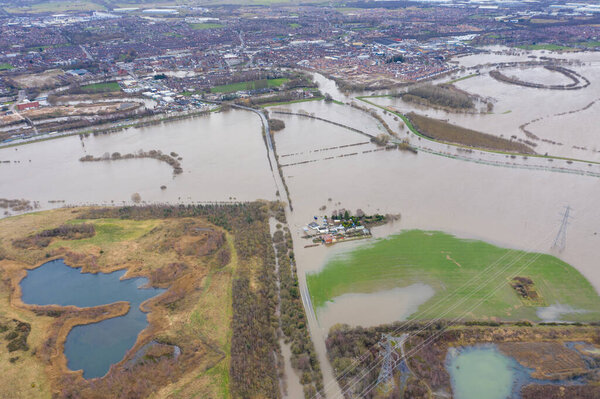 Aerial drone photo of the town of Allerton Bywater near Castleford in Leeds West Yorkshire showing the flooded fields and farm house from the River Aire during a large flood after a storm.