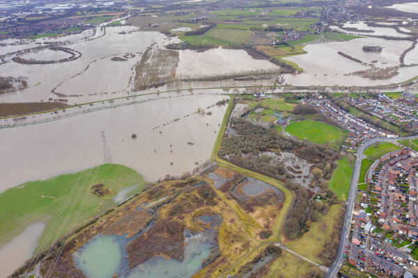 Aerial drone photo of the town of Allerton Bywater near Castleford in Leeds West Yorkshire showing the flooded fields and farm house from the River Aire during a large flood after a storm.