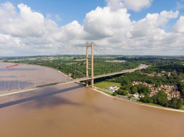 Humber Köprüsü 'nün geniş bir resmi, Kingston yakınlarındaki Hull' da, Yorkshire, İngiltere 'nin Doğu Binicisi, tek açıklıklı yol asma köprüsü, güneşli bir günde gökyüzünde birkaç beyaz bulutla çekildi..