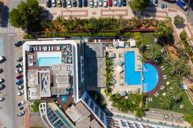 İspanya 'daki güzel İbiza adasının havadan çekilmiş fotoğrafı otel kompleksleri ve yüzme havuzları olan cadde ve sahil manzarasını gösteriyor.