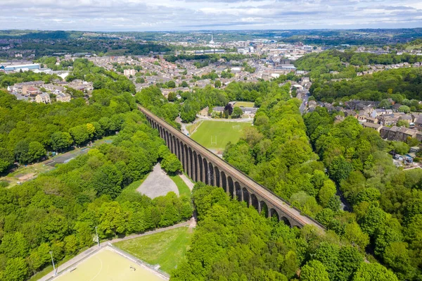 Aerial photo of a scenic view of the Lockwood Viaduct located in the town of Huddersfield borough of Kirklees in West Yorkshire showing the historic railway viaduct along side trees in the woods