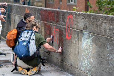 Leeds UK, 18 Temmuz 2019: Victoria Köprüsü 'ndeki Leeds Şehir Merkezi' nde düzenlenen Soykırım İsyanı Protestocuları protestonun ardından temizlik yaparken gösteriyor.