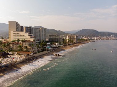 Güzel sahil ve Meksika 'daki Puerto Vallarta kasabasının hava fotoğrafları, bulutlu bir günde arka planda dağlarla birlikte Jalisco olarak bilinen eyaletin Pasifik kıyısında yer almaktadır..