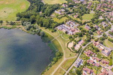 İngiltere 'deki Milton Keynes köyünün hava fotoğrafı, güneşli bir yaz gününde yukarıdan bir İHA ile çekilen tipik bir İngiliz konutlarını gösteriyor.