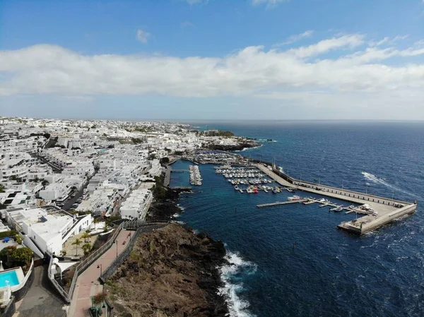 Aerial photo of the beautiful Boats and Boat Harbour Marina and pier taken in Lanzarote in Spain one of the Canary islands, showing all kinds of sailing boats in the calm ocean at Marina Puerto Calero
