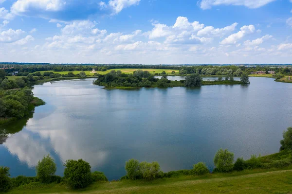 İngiltere 'deki Milton Keynes köyünün havadan çekilmiş fotoğrafı güneşli bir yaz gününde yukarıdan bir İHA ile çekilmiş büyük bir gölü gösteriyor.