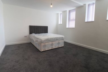 Yeni dekore edilmiş tipik bir İngiliz yatak odası. Geniş bir yatak odası ve gardırobu var. Beyaz duvarları var..