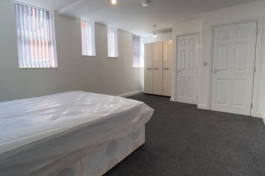 Yeni dekore edilmiş tipik bir İngiliz yatak odası. Geniş bir yatak odası ve gardırobu var. Beyaz duvarları var..