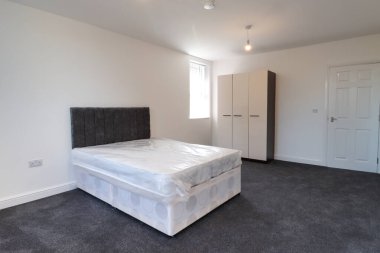 Yeni dekore edilmiş tipik bir İngiliz yatak odası. Geniş bir yatak odası ve gardırobu var. Beyaz duvarları var..