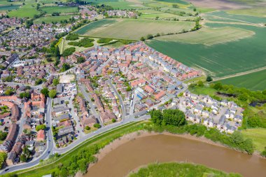 İngiltere 'nin York North Yorkshire kentindeki Selby kasabasının hava fotoğrafında Ouse nehri kıyısında yeni inşa edilmiş evler ve yaz mevsiminde çiftçi tarlaları görülüyor.