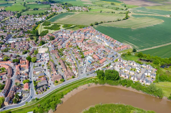 Aerial photo of the historical village town centre of Selby in York North Yorkshire in the UK showing the rows of newly built houses along side the River Ouse and farmers fields in the summer time