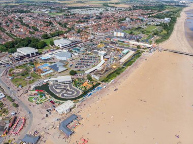 Doğu Lindsey 'deki İngiliz sahil kasabası Skegness' in havadan çekilmiş bir fotoğrafı. İngiltere 'nin bir semti. Panayır alanındaki lunapark gezilerini ve ailelerin sahilde eğlenip rahatlamalarını gösteriyor..
