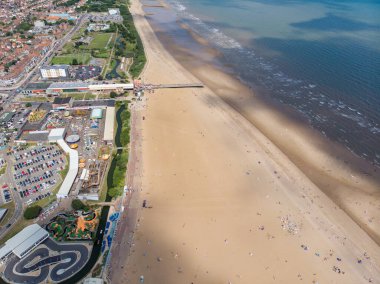 Doğu Lindsey 'deki İngiliz sahil kasabası Skegness' in havadan çekilmiş bir fotoğrafı. İngiltere 'nin bir semti. Panayır alanındaki lunapark gezilerini ve ailelerin sahilde eğlenip rahatlamalarını gösteriyor..