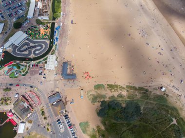 Doğu Lindsey 'deki İngiliz sahil kasabası Skegness' in havadan çekilmiş bir fotoğrafı. İngiltere 'nin bir semti. Panayır alanındaki lunapark gezilerini ve ailelerin sahilde eğlenip rahatlamalarını gösteriyor..