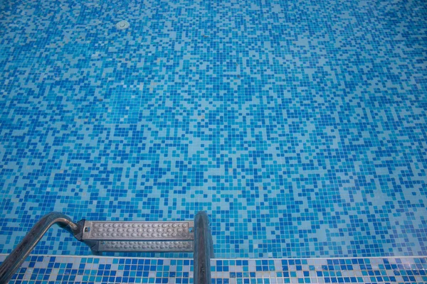 靠近一个蓝色的酒店游泳池 游泳池里有蓝色的马赛克瓷砖 还有通往水面的梯子 — 图库照片