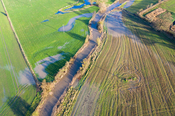 Aerial photo of the British country side fields in the winter time showing a river that has burst it's bank to overspill water on the fields, taken in the town of Wetherby in Yorkshire in the UK