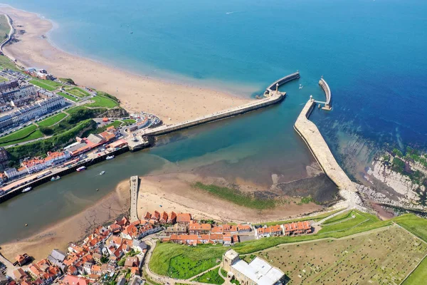 Aerial photo of the beautiful town of Whitby in the UK in North Yorkshire in the UK showing the beach and harbour on a hot sunny summer