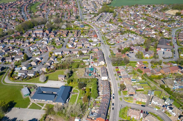 İngiltere 'nin Leeds West Yorkshire kentindeki Kippax kasabasının hava fotoğrafı güneşli bir yaz gününde gökyüzünde beyaz kabarık bulutlar olan konut evlerini gösteriyor..