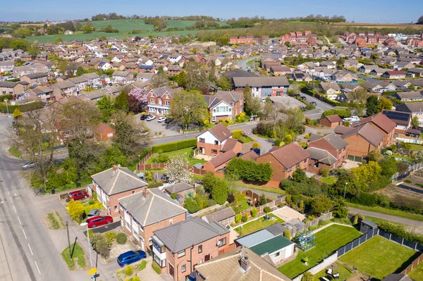 İngiltere 'nin Leeds West Yorkshire kentindeki Kippax kasabasının hava fotoğrafı güneşli bir yaz gününde gökyüzünde beyaz kabarık bulutlar olan konut evlerini gösteriyor..