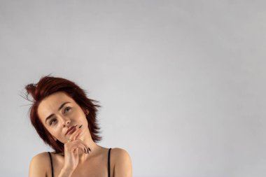 Stüdyoda siyah elbise giyen, beyaz arka planda kızıl saçlı, beyaz saçlı, beyaz saçlı, beyaz, çekici bir kadın model..