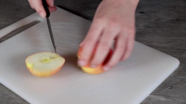 Una Joven Una Cocina Cortando Una Manzana Roja Una Tabla — Vídeos de Stock