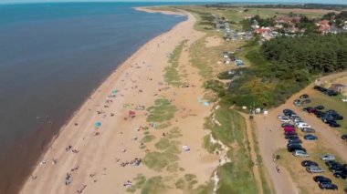 İngiliz sahil kasabası Hunstanton Norfolk 'un hava görüntülerinde plajın güney ucunda güneşlenen, dinlenen ve oynayan insanlar görülüyor..