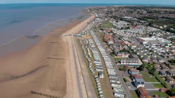 ハンストンノーフォークの英国の海辺の町の空中映像は ビーチフロントの長い砂浜と海の前でキャラバンやキャンプ場を示しています — ストック動画