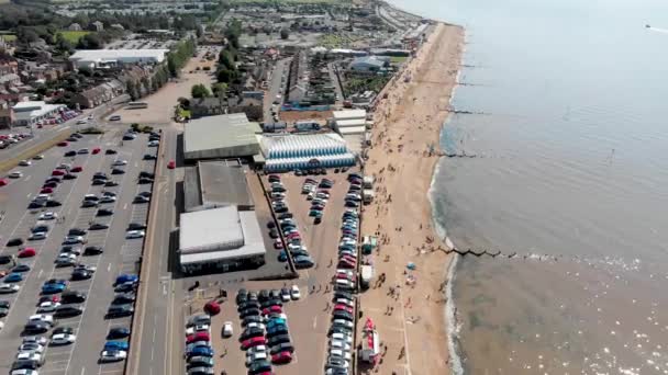 ハンストンノーフォークの英国の海辺の町の空中映像は 休日のメーカーがリラックスして夏の時間に日当たりの良いビーチで楽しんでいることを示しています — ストック動画