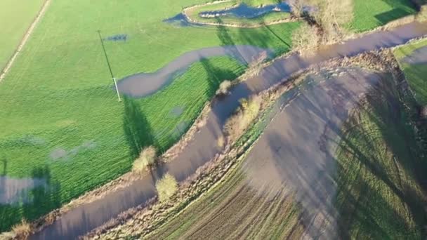 英国のウェザビー ヨークシャーの町で撮影されたフィールド上の水を流出させるために銀行だバーストしている川を示す冬の間の英国の田舎のフィールドの空中映像 — ストック動画