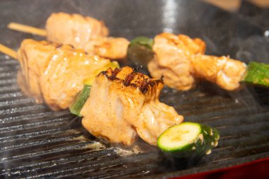 Bahar Somonu ve Karides Şişleri bir tavada pişiyor ve dumanları çıkıyor.