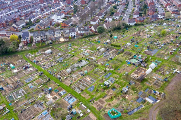 Aerial photo of a community garden allotment in the city of Leeds in the UK showing the community gardens alone side rows of residential houses taken in the string time