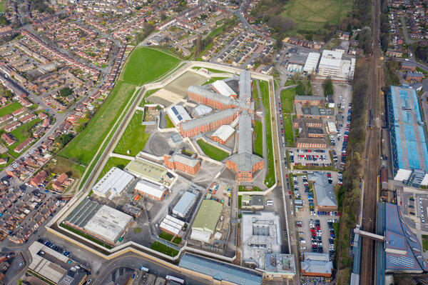 Aerial drone photo of the town centre of Wakefield in West Yorkshire in the UK showing the main building and walls of Her Majesty's Prison, also know as HMP Wakefield taken in the spring time