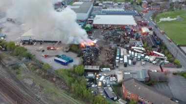 Leeds UK, 24 Nisan 2021: İngiltere 'nin Leeds West Yorkshire kentindeki Hunslet kasabasındaki bir hurdalıkta çıkan büyük bir yangının hava görüntüleri itfaiyecilerin alevlerle mücadele ettiğini gösteriyor.