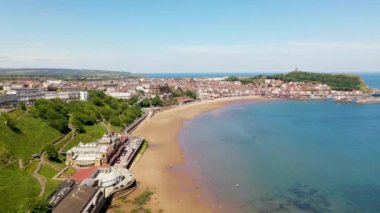 Kuzey Yorkshire, İngiltere 'deki Scarborough kasabasındaki kumsalın insansız hava aracı görüntüleri güneşli bir yaz gününde kumsalda eğlenen insanları gösteriyor.
