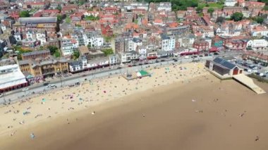 Kuzey Yorkshire, İngiltere 'deki Scarborough kasabasındaki kumsalın insansız hava aracı görüntüleri güneşli bir yaz gününde kumsalda eğlenen insanları gösteriyor.