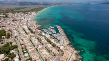 Aerial drone footage of the beach front on the Spanish island of Majorca Mallorca, Spain viewed from above on a bright sunny summers day showing the beach front in the village of Can Picafort