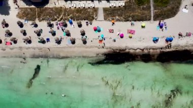 Aerial drone footage of the beach front on the Spanish island Majorca Mallorca, Spain showing the beach known as Platja de Muro in the village of Alcdia on a bright sunny summers day